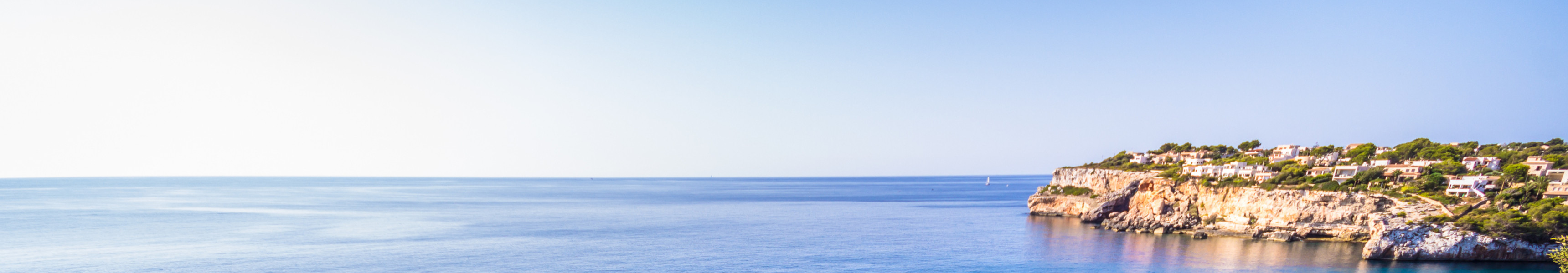 Natürlicher Felsbogen Es Pontàs im türkisblauen Mittelmeer vor der Küste Mallorcas, umgeben von Klippen und grüner Vegetation.