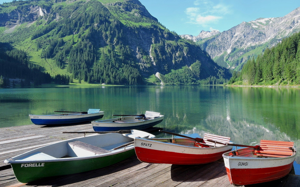 Boote am Steg mit Berglandschaft in Tirol 