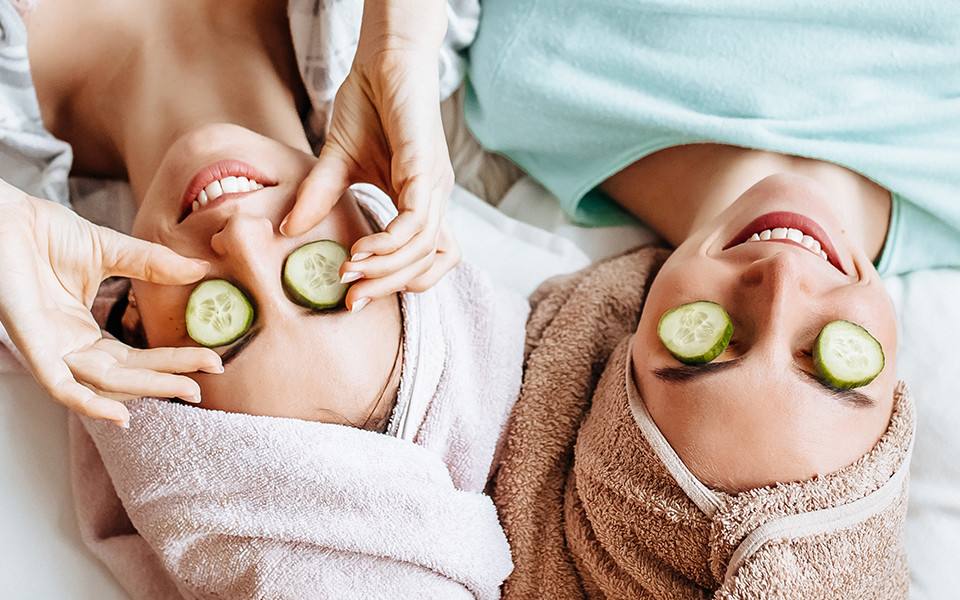Freundinnen beim Wellness mit Gurken auf den Augen 